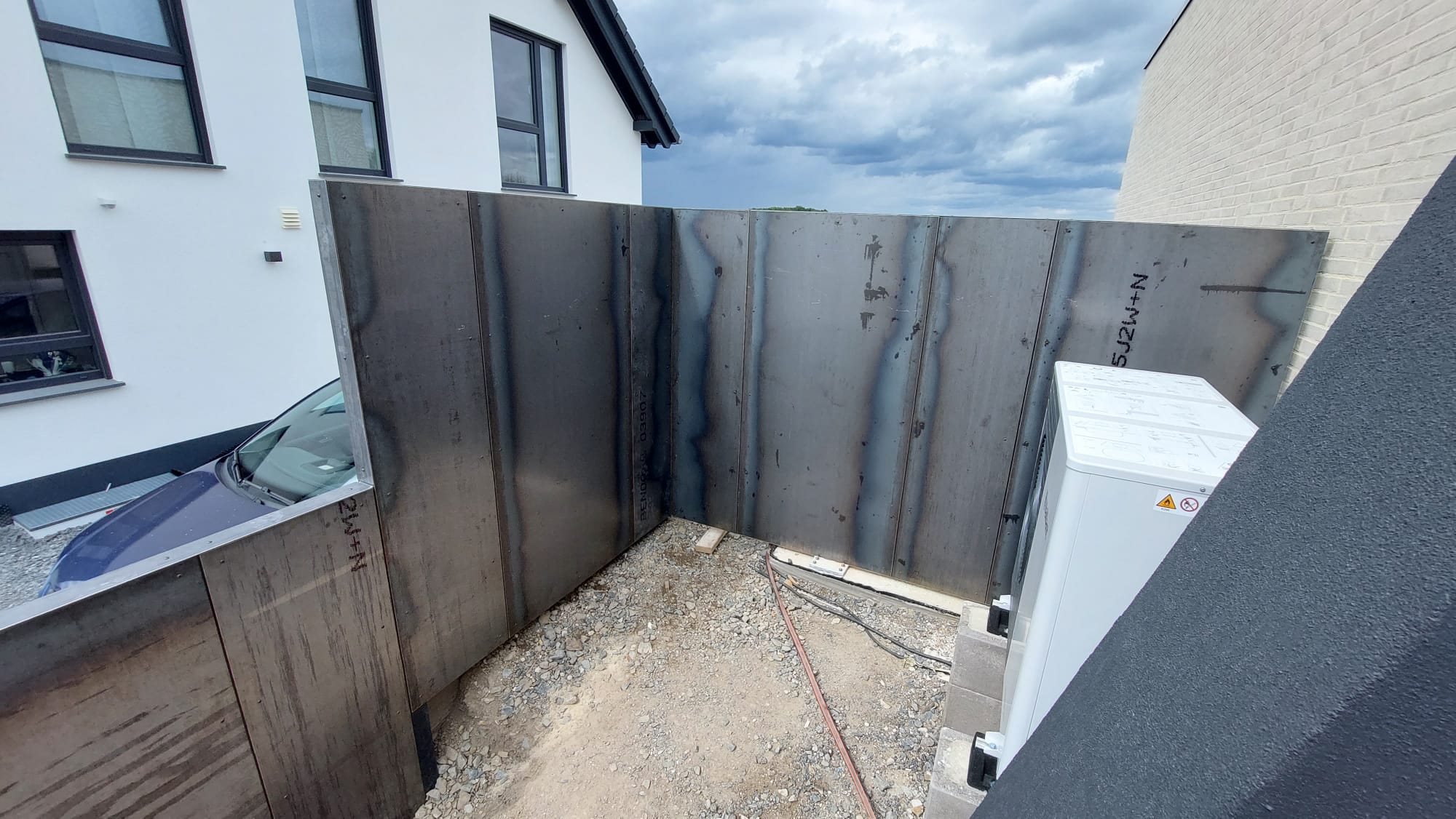 Änderungsarbeiten an einer Stahlwand mit sichtbaren Schweißnähten am Wohnhaus