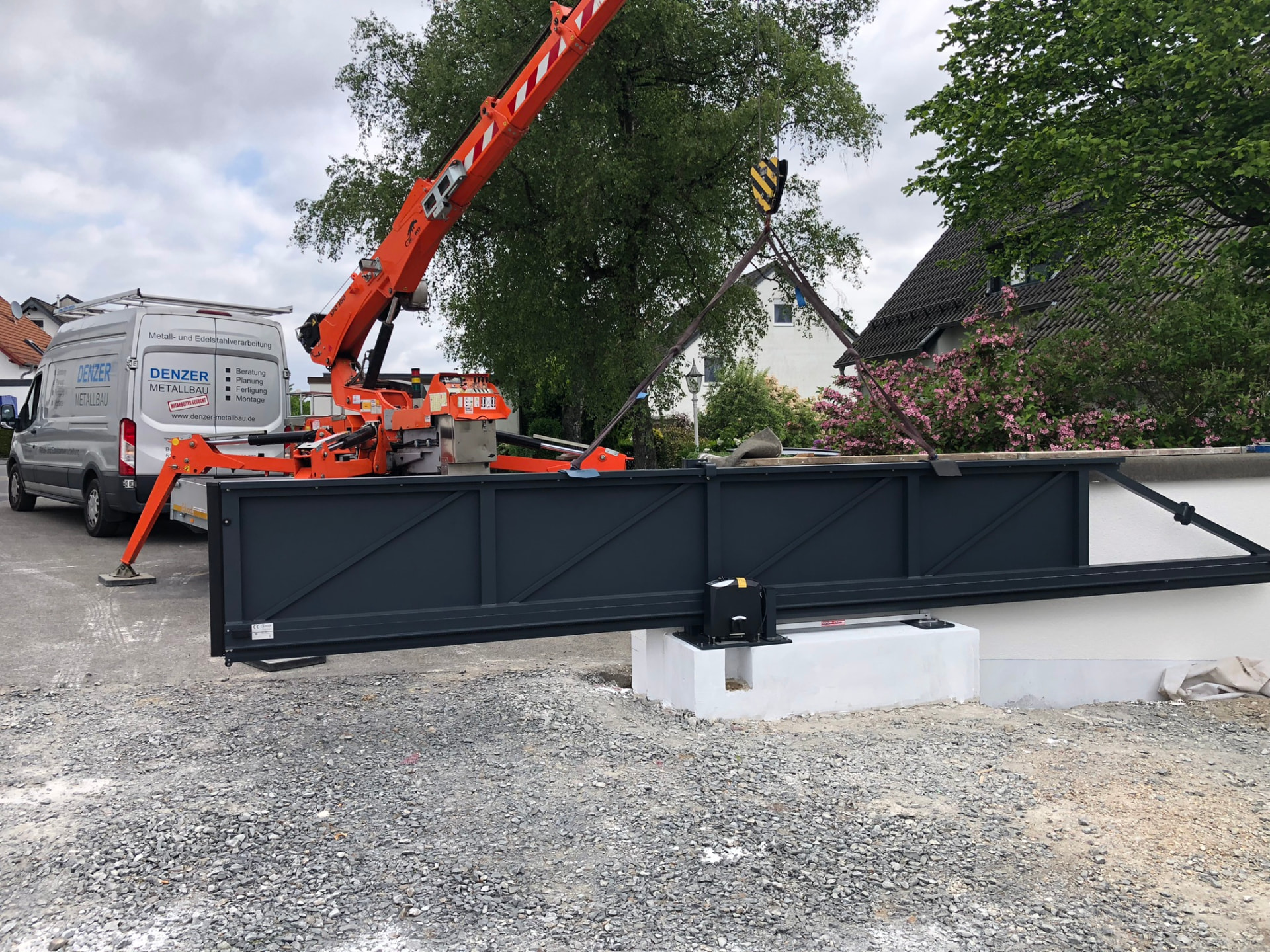 Montage eines großen Schiebtors mit Mobilkran auf der Baustelle